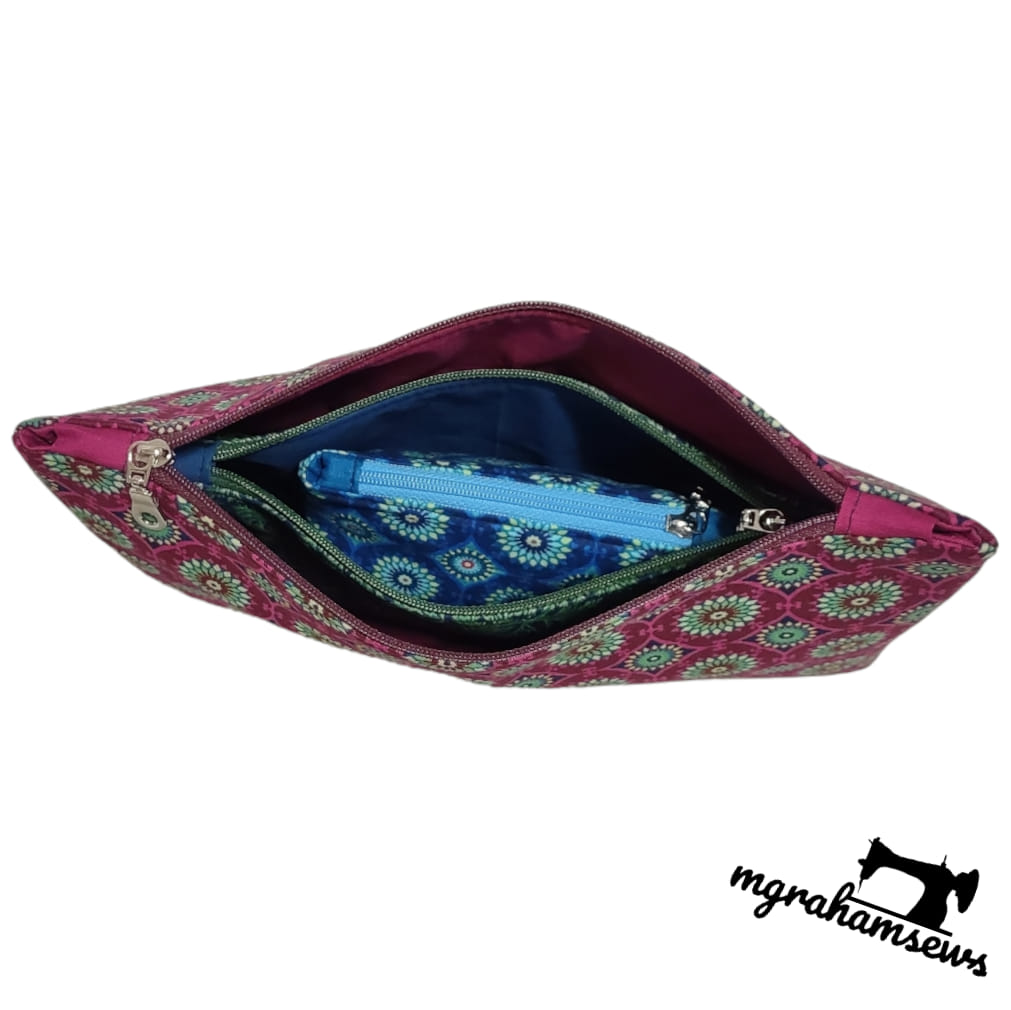 Pink fabric pouch with floral pattern and blue interior on a white background, featuring M Graham logo.