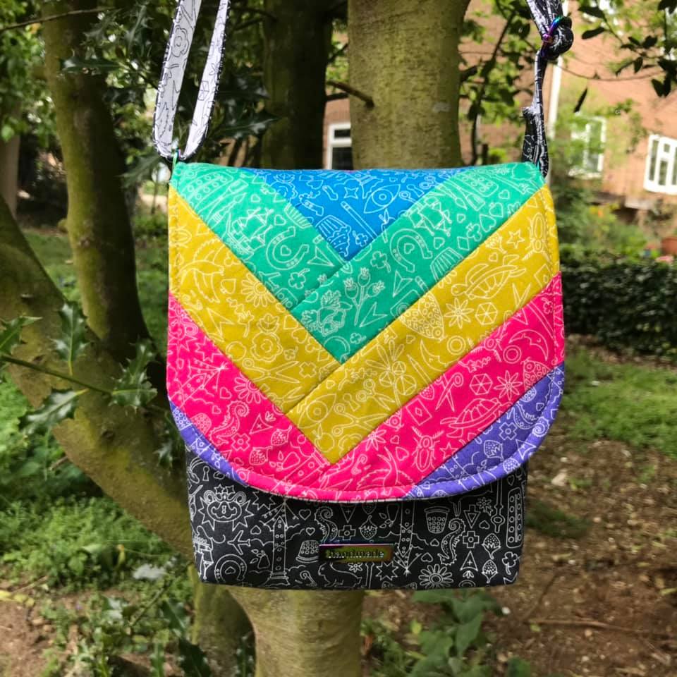 The Crossbody Bag PDF Sewing Pattern rear view with rainbow fabric and black contrast