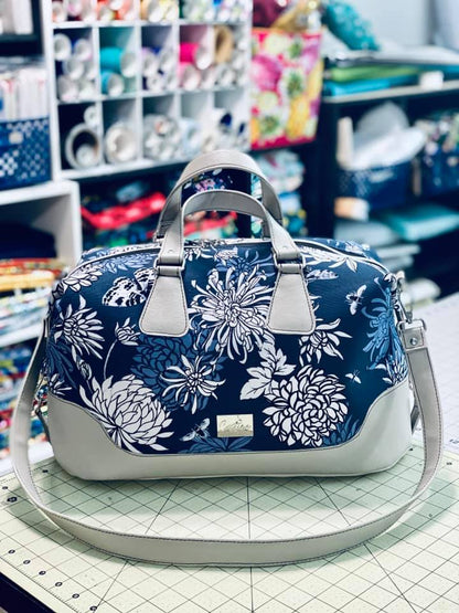 Brooklyn Bag from Swoon Sewing Patterns, made by Monica Ann Bernstine from Castine Handcrafted in white and blue floral patterned fabric with silvery grey vinyl accents and silver bag hardware