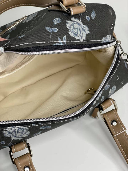 Inside view of the Brooklyn Handbag from Swoon Sewing Patterns, made by Lauren Mormino from More Me Know using grey rose patterned fabric and light brown coloured vinyl, with silver hardware