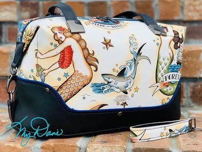 Brooklyn Bag from Swoon Sewing Patterns, made by Kimberly Cummins from MyDani Bags in nautical tattoo fabric with black vinyl accents, blue piping, and dark grey hardware