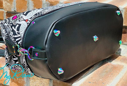 Base of the Brooklyn Bag from Swoon Sewing Patterns, made by Kimberly Cummins from MyDani Bags in Tula Pink fabric with black vinyl accents and rainbow coloured hardware