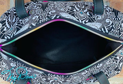 Inside view of the Brooklyn Bag from Swoon Sewing Patterns, made by Kimberly Cummins from MyDani Bags in Tula Pink fabric with black vinyl accents and rainbow coloured hardware