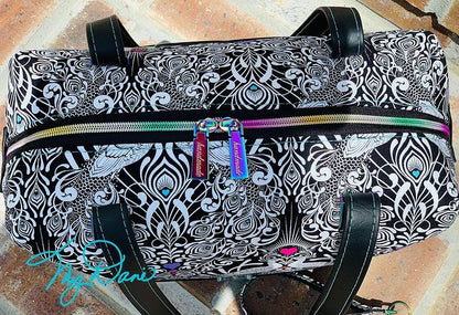 Top view of the Brooklyn Bag from Swoon Sewing Patterns, made by Kimberly Cummins from MyDani Bags in Tula Pink fabric with black vinyl accents and rainbow coloured hardware